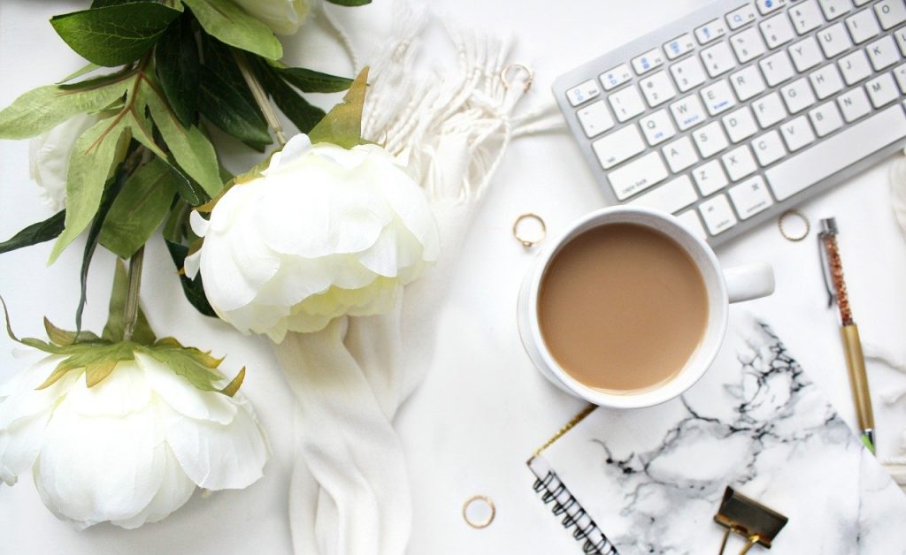 Arbeitsplatz mit Kafffee und Blumen