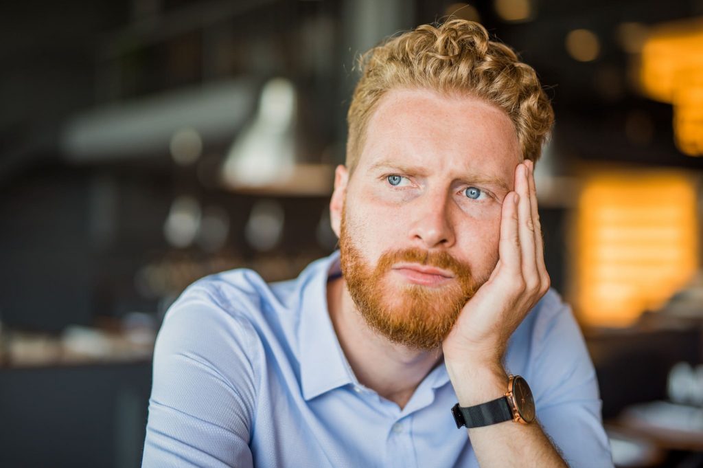 Nachdenklicher Mann überlegt, ob er seinen Job kündigen soll oder nicht